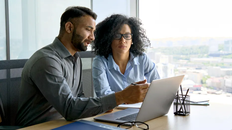 Two people look at a computer screen.