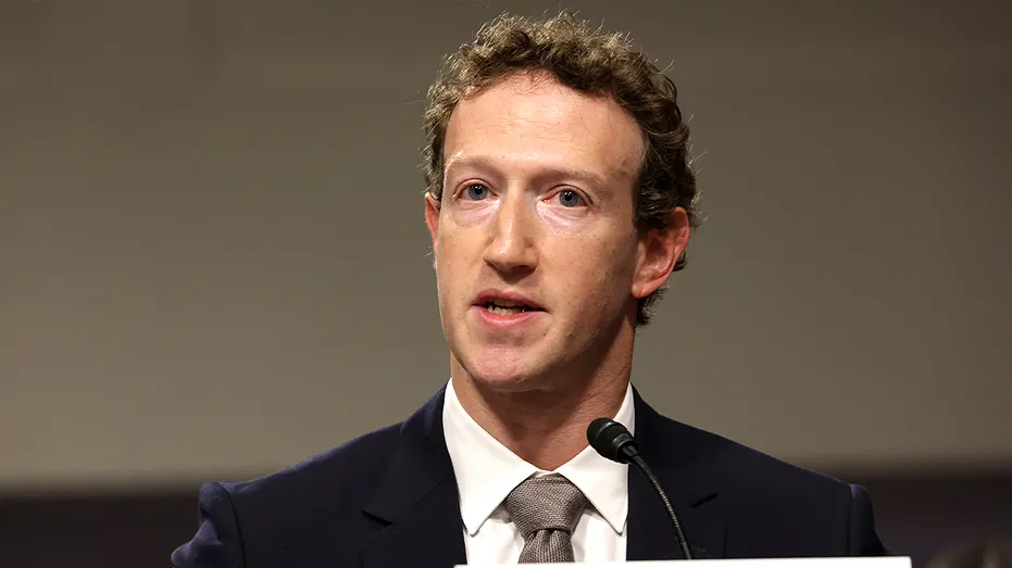 Mark Zuckerberg sits at a witness table