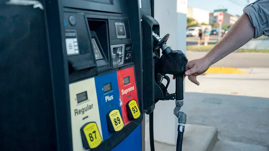 Person reaching for gas pumpp