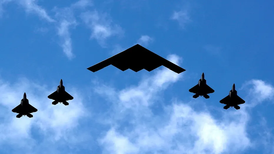 B-2 bomber flanked by F-22 Raptor fighter planes