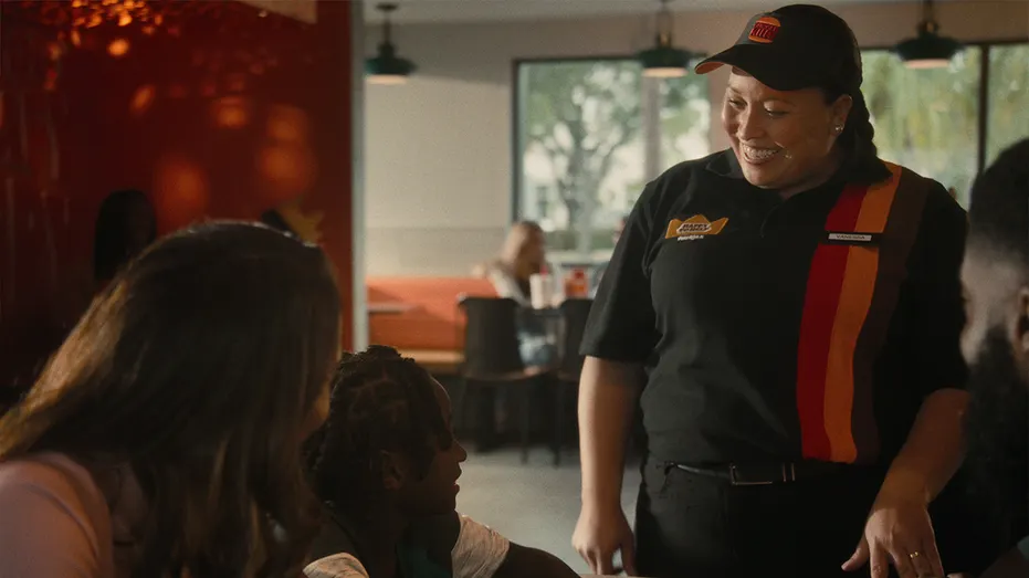 A Burger King worker greets customers.