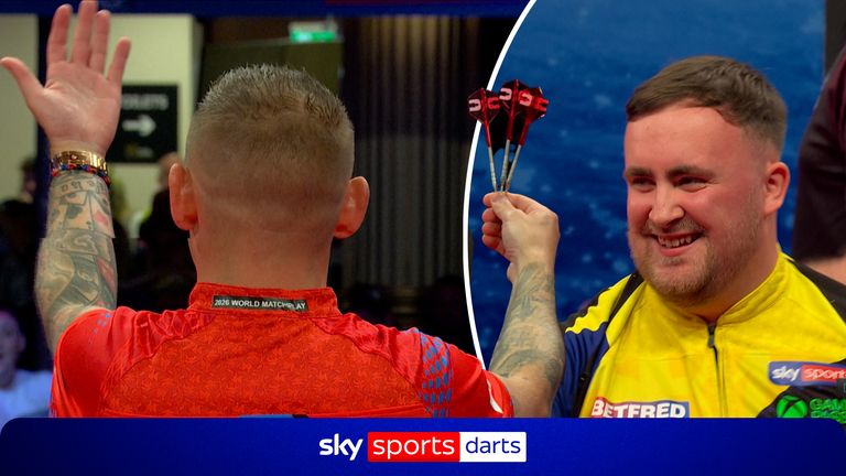 Nathan Aspinall offers up his darts to the crowd after Luke Littler almost hits his second nine-darter of the match. 