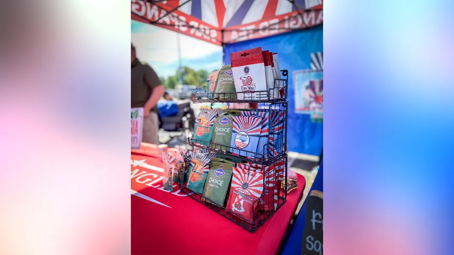 Bags of Star Spangled Tea & Coffee products displayed in a black wire rack at an outdoor vendor booth