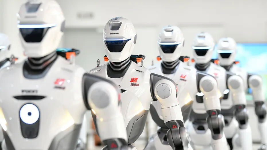 Humanoid robots stand on display at a robotics exhibition