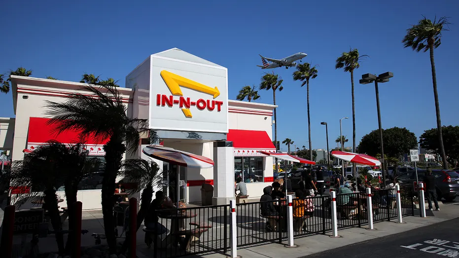 A plane flies over an In-N-Out Burger outlet in Los Angeles