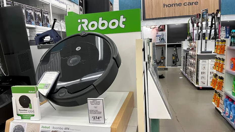 A black Roomba vacuum on display in a store.