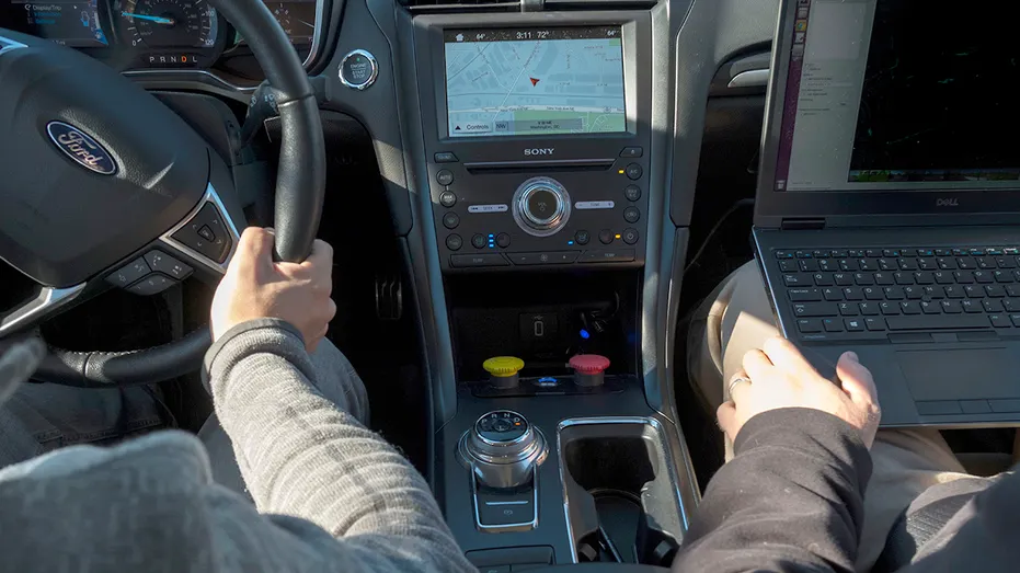 People driving a Ford with maps displayed