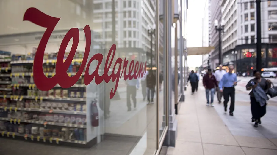Pedestrians pass in front of a Walgreens store