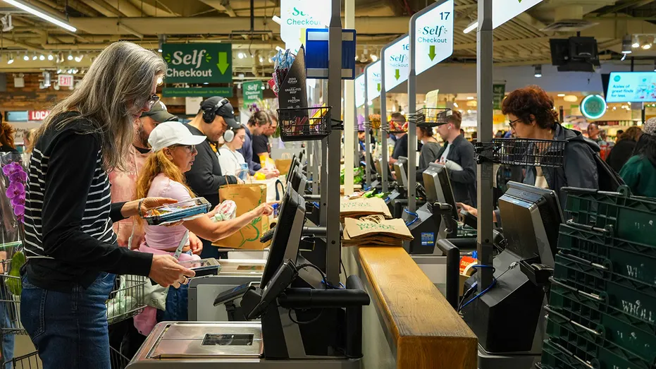 Customers use self checkout at Whole Foods