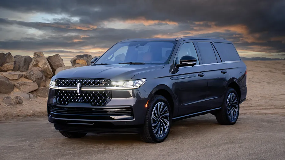 A Lincoln Navigator SUV is displayed against a desert backdrop at sunset.