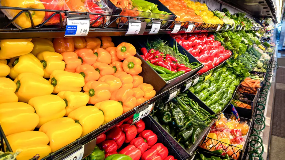 Jalapeño peppers and other fresh produce displayed in the produce section of a grocery store