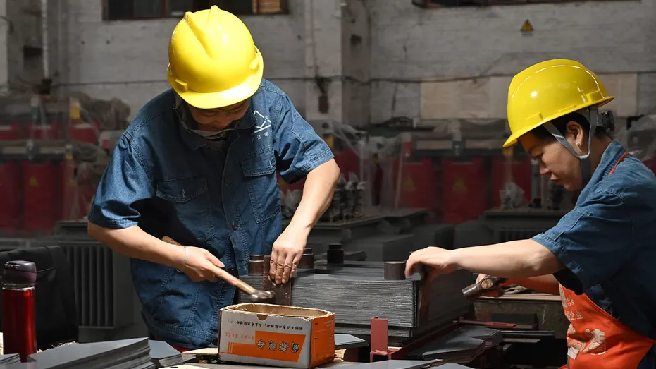 Workers assemble electrical transformers at a factory in Neijiang, China