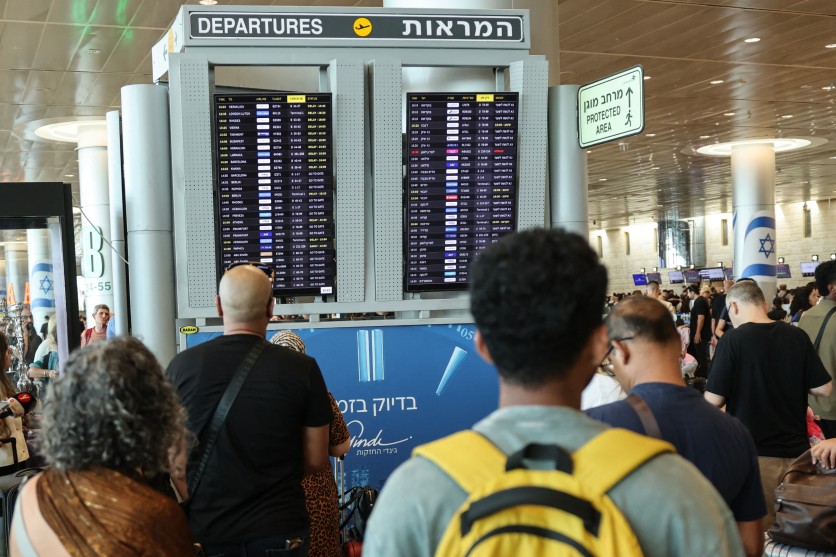 Passengers check flight information board amid disruptions