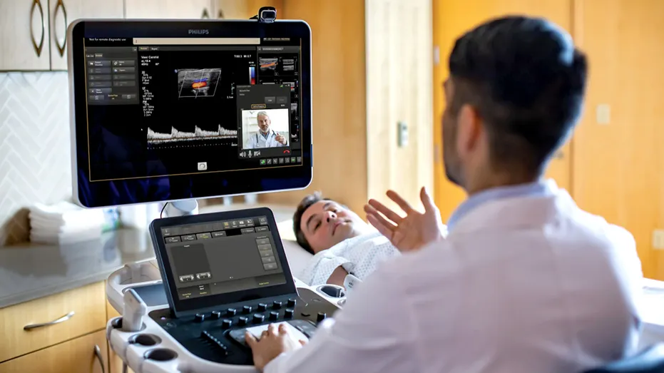Two clinicians using Collaboration Live while patient is on the table undergoing an ultrasound scan.