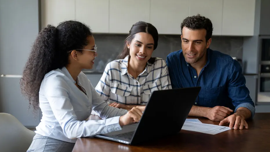 A financial advisor is seen talking with a couple.