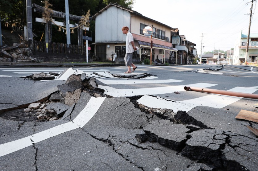 man walks along destroyed road Uki Kumamoto