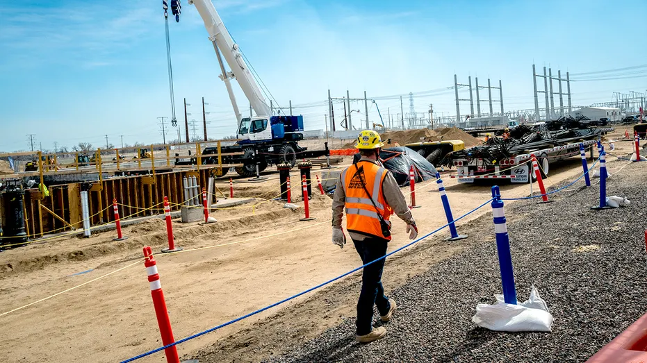 A construction worker walks along a site in Colorado.