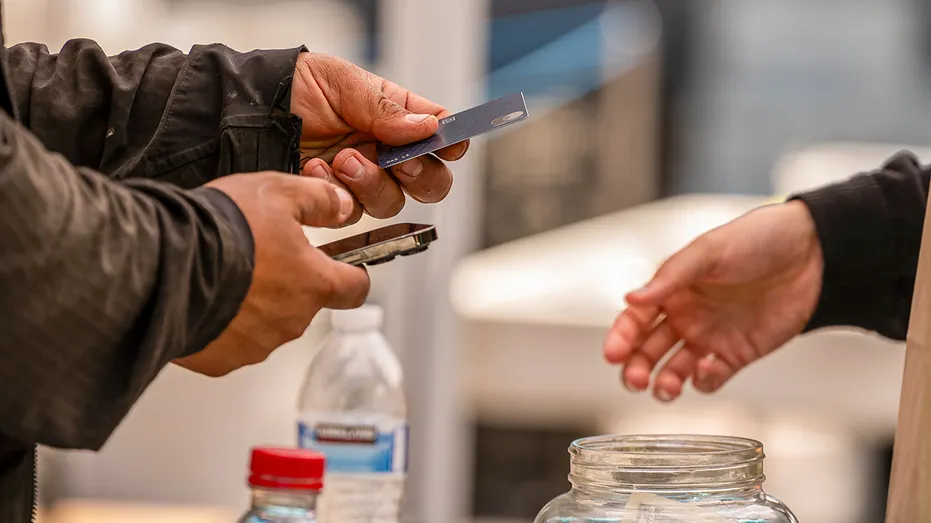 Person hands credit card to cashier
