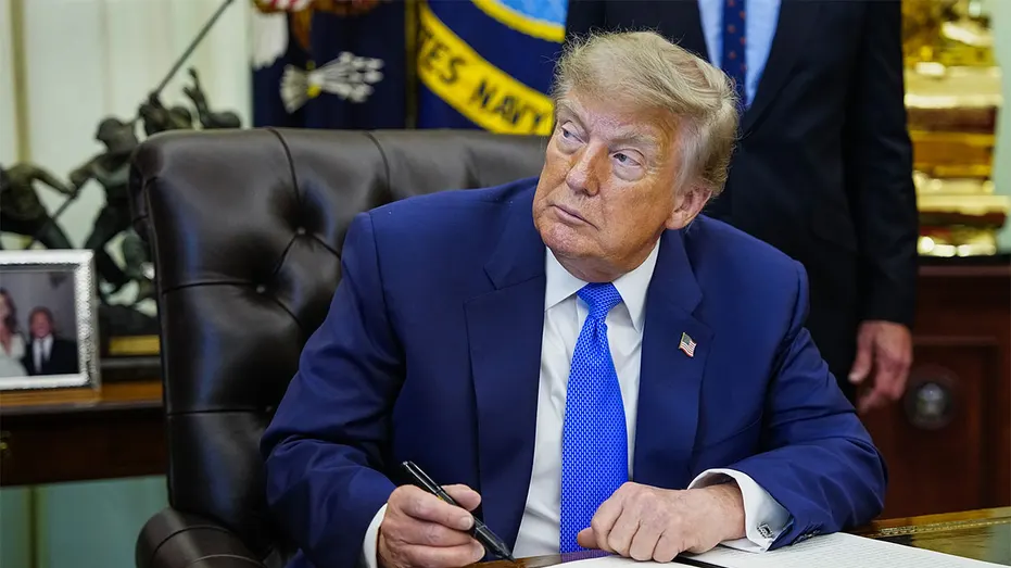 President Donald Trump signs an executive order in the Oval Office at the White Housex