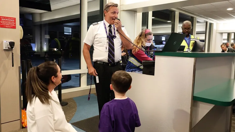 An Avelo Airlines worker addresses passengers at a gate before a flight.