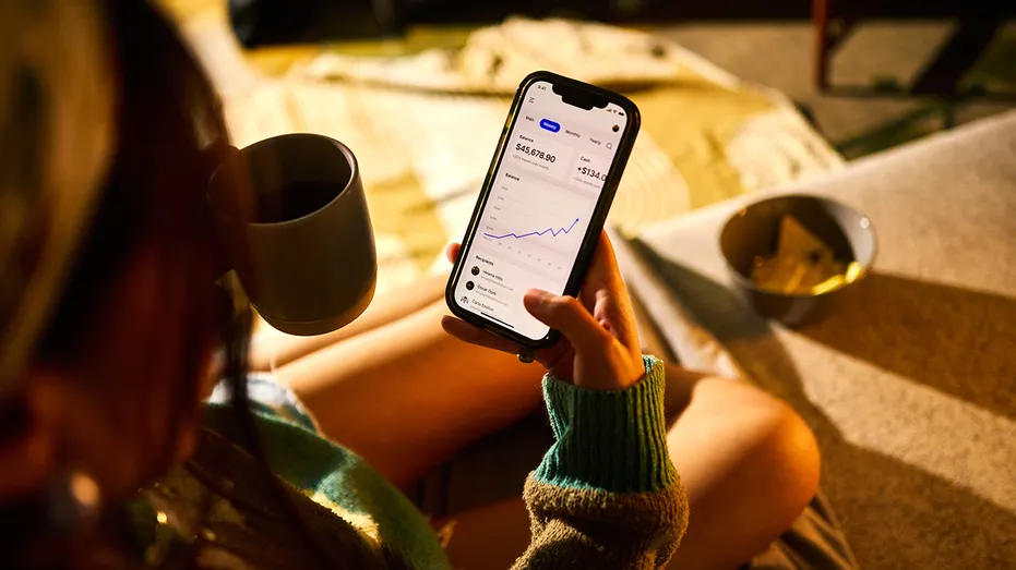 A person checks the performance of an investment portfolio on a smartphone.