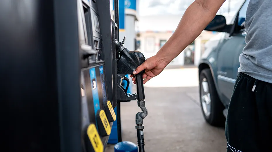 Person's hand pulls for gas station pump