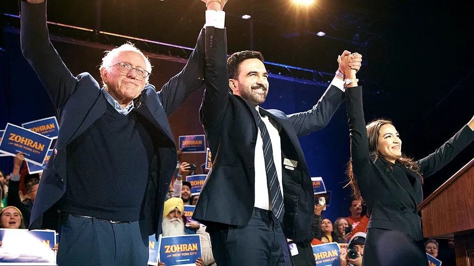 Zohran Mamdani celebrates on stage with Bernie Sanders and Alexandria Ocasio-Cortez during a campaign rally at Forest Hills Stadium in Queens, New York.