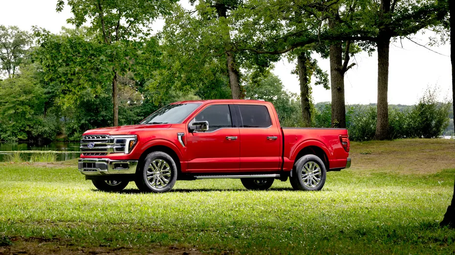A red Ford F-150 Lariat in the woods.