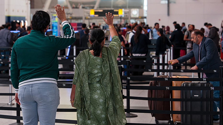People wave goodbye to a traveler