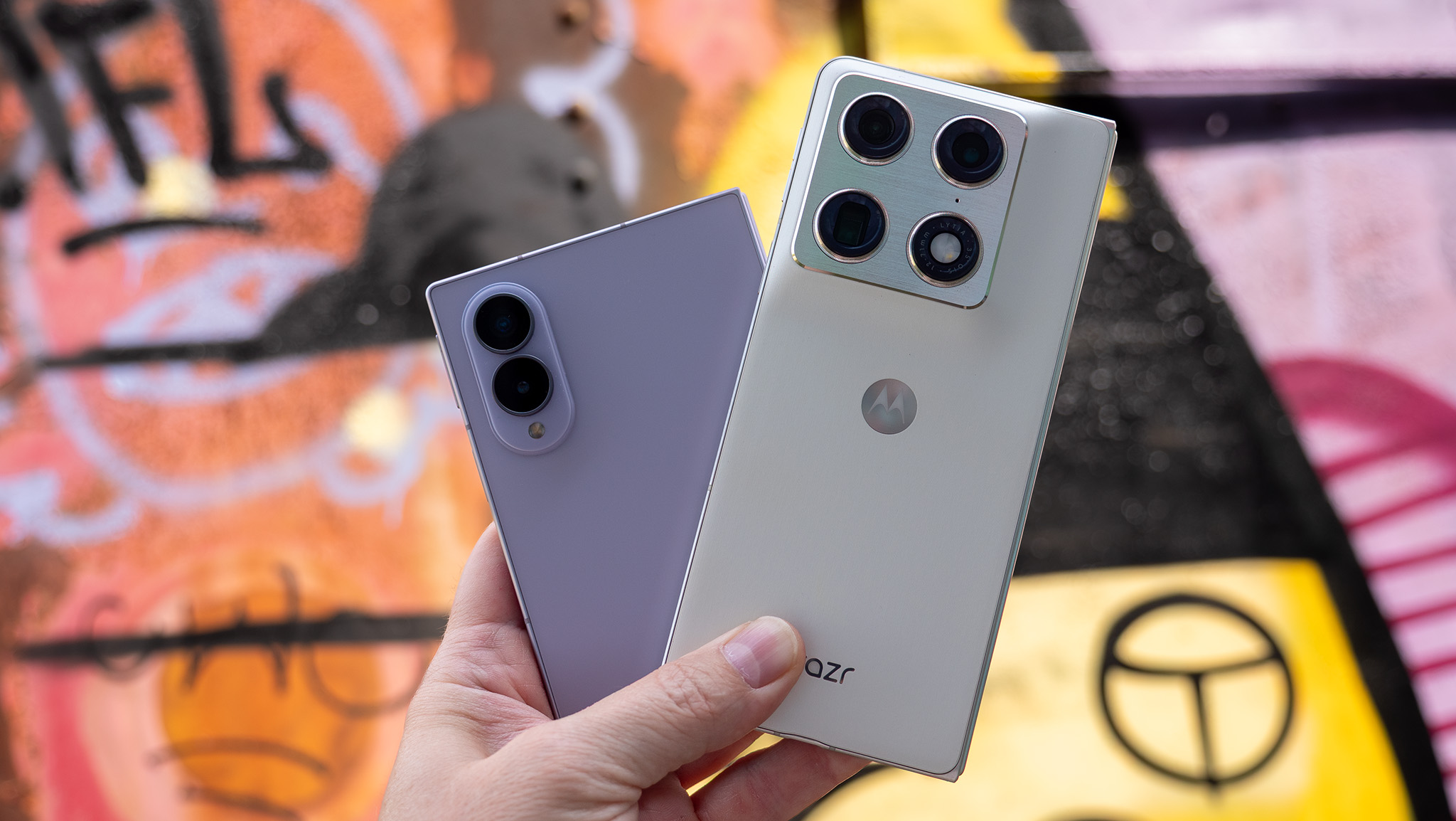 Comparing the Motorola Razr Fold (white) and the Samsung Galaxy Z Fold 8 (lavender)