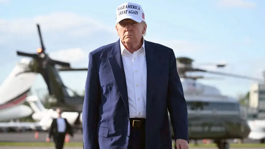 US President Donald Trump walks to speak to journalists.