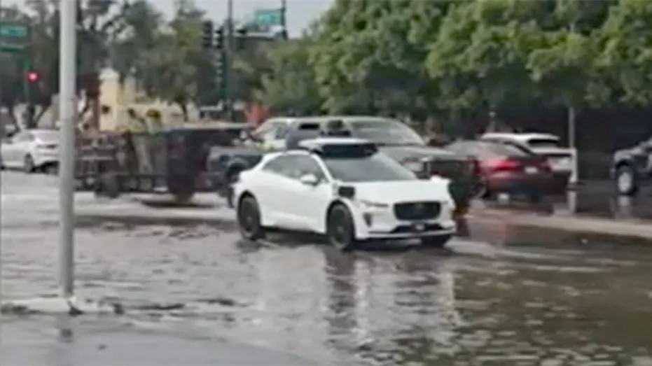 A Waymo vehicle seen on a flooded street.