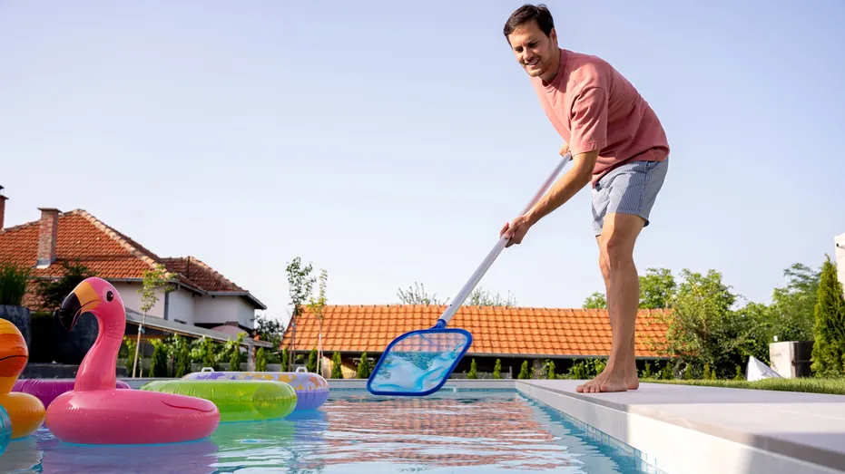 A man stands on the edge of a pool.
