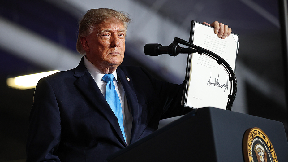 U.S. President Donald Trump signs an executive order to lower the cost of diesel fuel during a campaign rally.