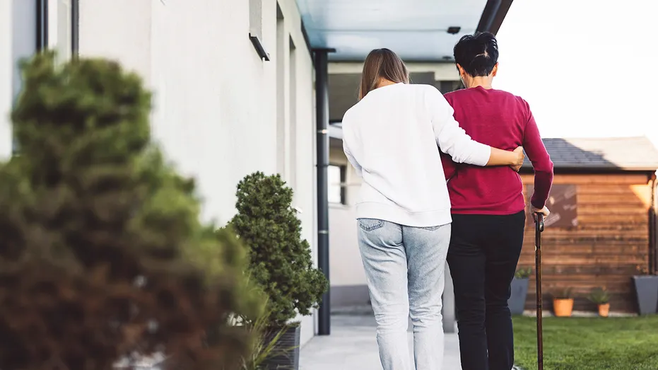 A caregiver helps an elderly lady