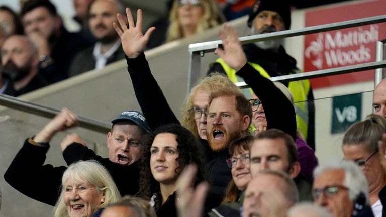 Prince Harry (centre) was spotted in the stands