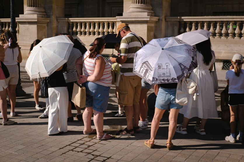 People shield themselves sun parasol severe heat